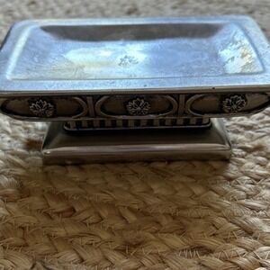 decorative silver-tone pedestal dish, likely used as a soap dish, trinket holder
